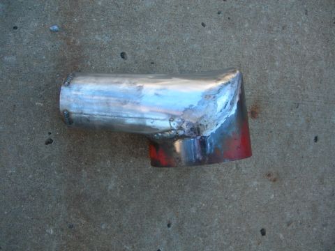 1984 Ford Bronco - A custom-welded metal pipe, likely for an exhaust or intake system, rests on concrete.