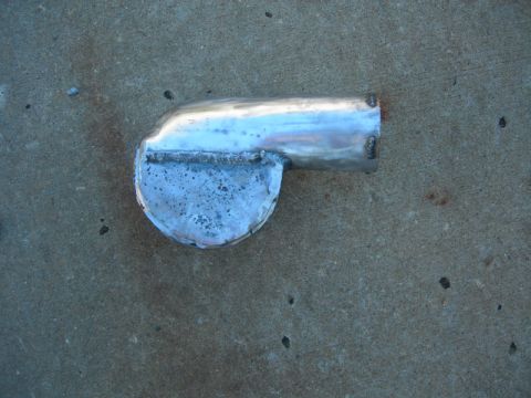 1984 Ford Bronco - A custom-fabricated exhaust pipe, likely for a diesel engine rebuild, is shown resting on a concrete surface.