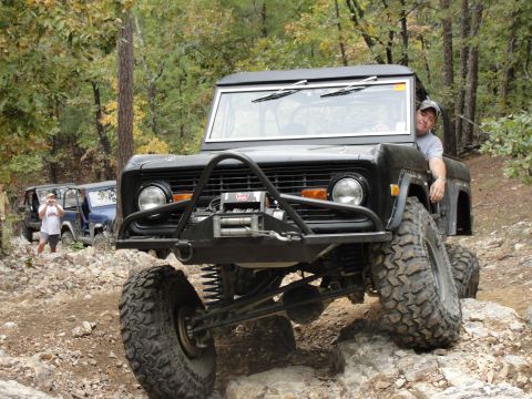 1967 Ford Mustang - Black Ford Bronco navigates a rocky off-road course with another Bronco in the background.
