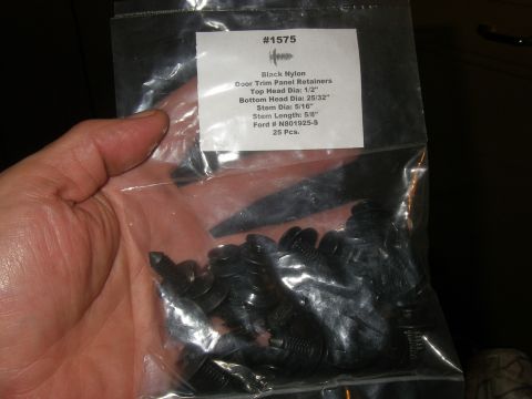 1990 Ford Bronco - A hand holds a bag of 25 black nylon door trim panel retainers with part number N801925-S.