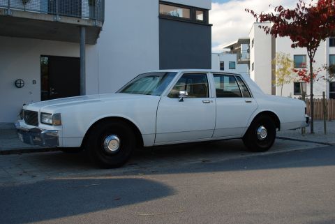 1998 Ford Crown Victoria - This white sedan has a boxy body style typical of 1980s American sedans.