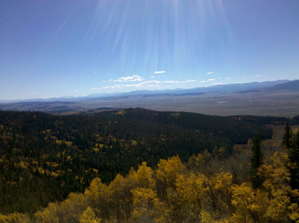 Mountain landscape with autumn trees and a bright blue sky