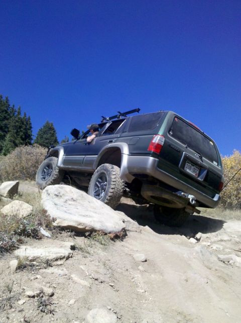 1996 Ford Bronco - This SUV navigates a challenging rocky trail under a clear blue sky.