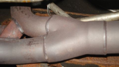 1988 Ford Bronco - Close-up view of a vehicle's exhaust system showing a Y-pipe connection.