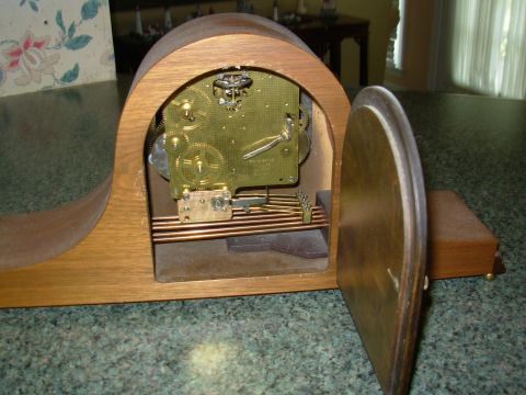 2004 Land Rover Land Rover - Close-up of a wooden mantel clock's internal brass clockwork mechanism.