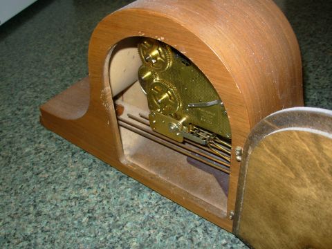 2004 Land Rover Land Rover - Close-up of a wooden clock's internal mechanism, revealing intricate brass gears and pendulum rods.