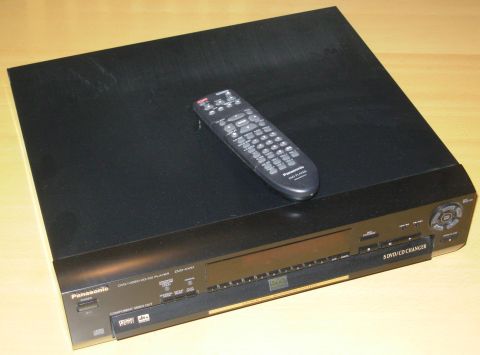 2004 Land Rover Land Rover - A Panasonic DVD/CD changer sits on a wooden surface with a remote control placed on its lid.