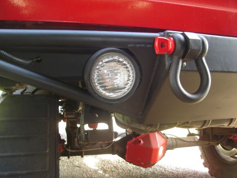 1989 Ford Bronco - Close-up of an aftermarket rear bumper assembly, showing a tow shackle and a circular light.