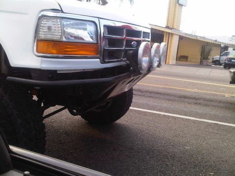 1986 Ford Bronco - Front view of a white truck, possibly a 1992 Ford F-Series, equipped with off-road lights and a custom bumper.