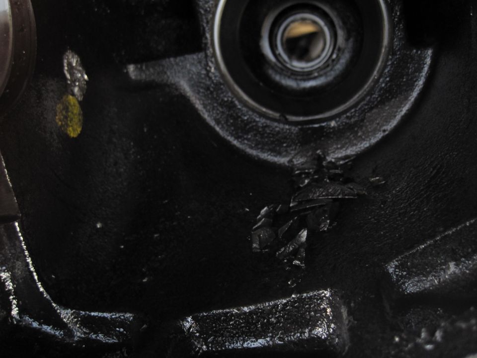 Black metal differential housing with a bearing race and damaged metal fragments