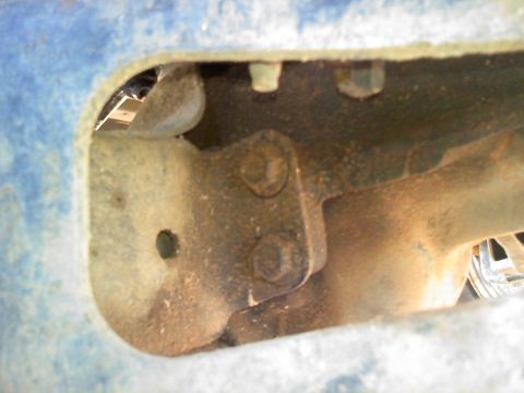 1990 Ford Bronco - Detail of a rusty suspension part, likely from a truck or SUV, with visible bolts and mounting hardware.