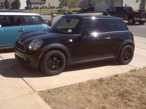 2010 MINI Cooper - A black MINI Cooper is parked on a concrete driveway next to another MINI Cooper.