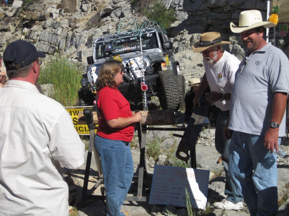 Modified Jeep Wrangler with large tires and roof rack, people gathered around it