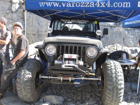 1989 Ford Bronco - A modified Jeep Wrangler is displayed under a blue canopy at an outdoor event.