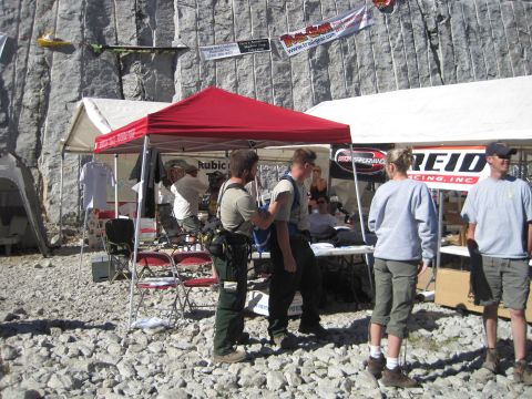 1989 Ford Bronco - An outdoor event is set up with tents and people gathered, with banners displayed against a large rock face.