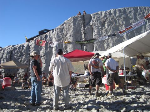 1989 Ford Bronco - A gathering of off-road enthusiasts at a rocky event, with vehicles positioned on a steep incline.
