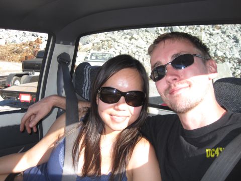 1989 Ford Bronco - Two people smile for a selfie from inside a vehicle, with another vehicle and trailer visible outside.