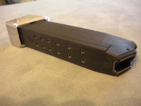 1996 Ford Bronco - A black gun magazine with a silver base is shown from the side, with visible bullet holes and caliber marking.