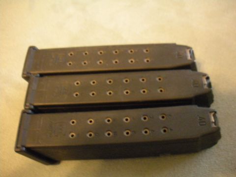 1996 Ford Bronco - Three firearm magazines are shown stacked on a textured surface.