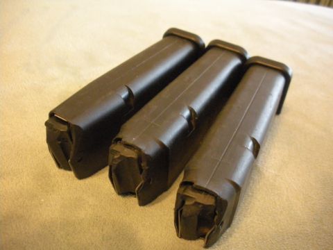 1996 Ford Bronco - Three black gun magazines are displayed on a textured surface, with the bottom ends clearly visible.