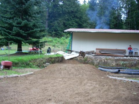 1994 Ford Escort - A scene of outdoor construction with a large dirt pile and a building.