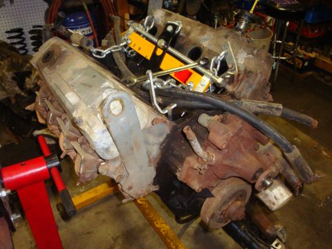 1989 Ford Bronco - Engine block on a stand, ready for removal or installation. Hoist is attached.