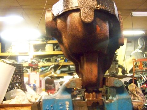 1989 Ford Bronco - A heavily rusted metal component is secured in a vise, likely for repair or inspection in a workshop setting.