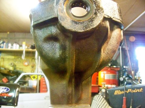 1989 Ford Bronco - Differential housing part shown in a workshop setting with tools and equipment in the background.