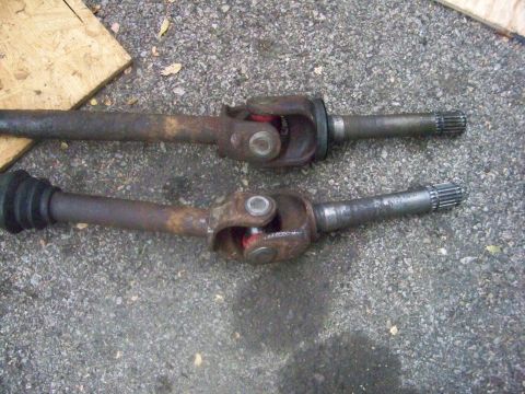 1989 Ford Bronco - Two driveshafts are shown side-by-side on a gravel surface.