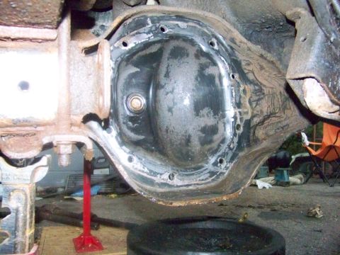 1989 Ford Bronco - Close-up of a vehicle's differential housing, showing the removed cover and surrounding suspension components.