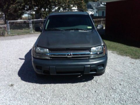 2003 Chevrolet TrailBlazer - The front grille and headlights of a dark-colored Chevrolet TrailBlazer are visible.