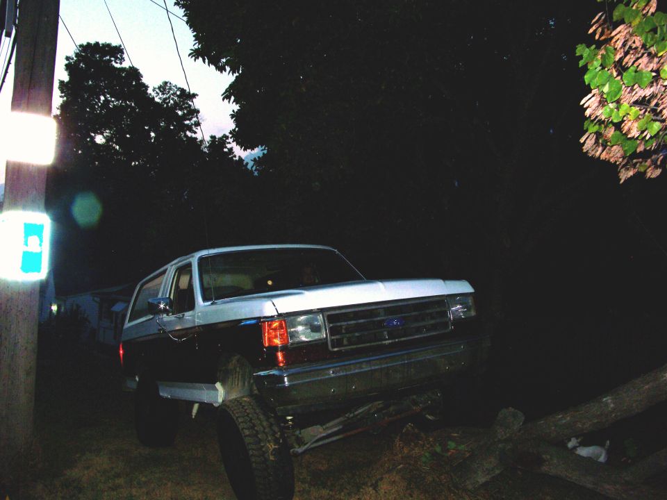 Silver and maroon SUV on a log, front 3/4 view