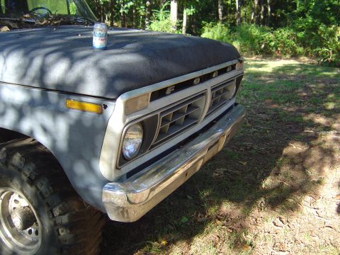 1986 Ford Bronco - Front view of a vintage Ford truck, showing its grille and hood with a beverage can.