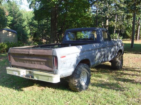 1986 Ford Bronco - This Ford pickup truck, likely from the mid-1970s, is shown from the rear in an outdoor setting.