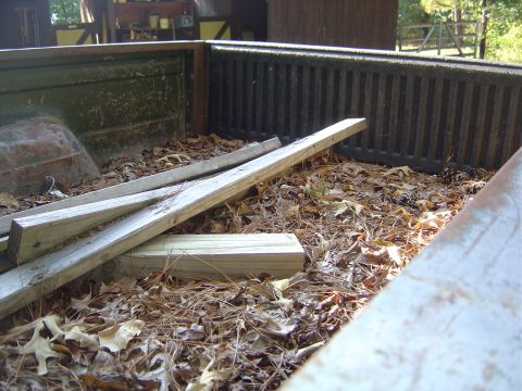 1986 Ford Bronco - The interior of a truck bed is filled with debris and lumber, with a watermark visible at the bottom right.