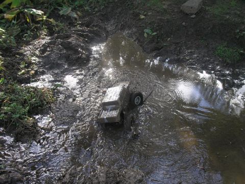 1994 Ford Escort - A toy truck navigates a muddy terrain, with a watermark visible in the corner.