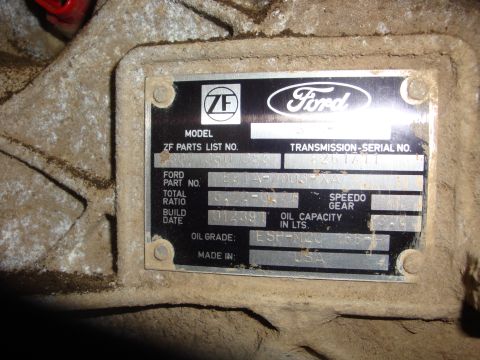 1989 Ford Bronco - A metal data plate on a transmission shows Ford and ZF logos, part numbers, and build date information.