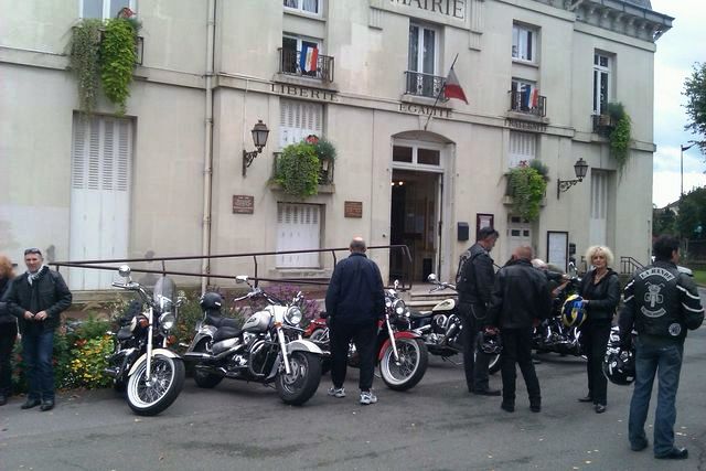 Motorcycles parked in front of a French Mairie building