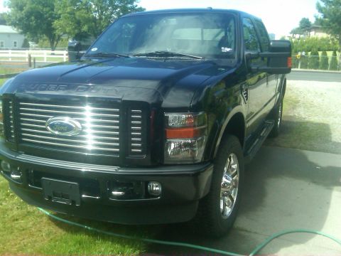 1988 Ford Bronco - This black Ford Super Duty pickup truck features a chrome grille and "SUPER DUTY" badging on the hood.