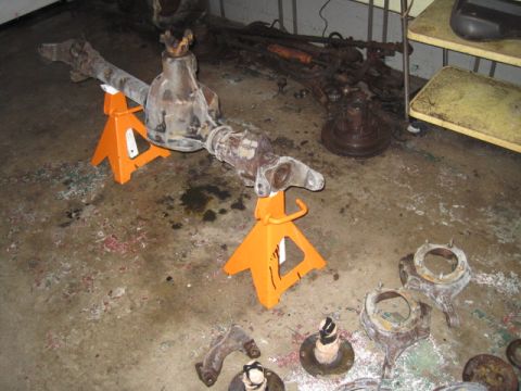 1979 Ford Bronco - Front axle assembly and other suspension components are laid out on the floor.