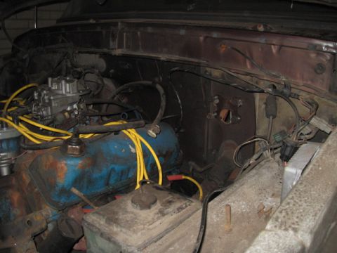 1979 Ford Bronco - Close-up view of an engine bay, showing a blue engine block and yellow spark plug wires.