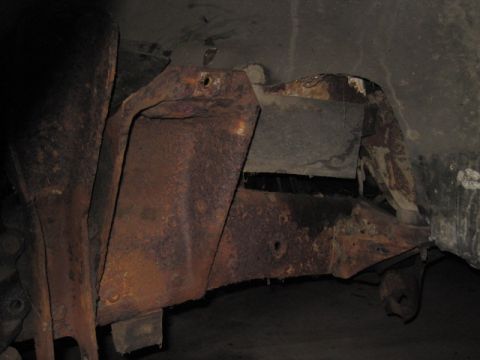 1979 Ford Bronco - Close-up view of heavily corroded vehicle frame and suspension components.