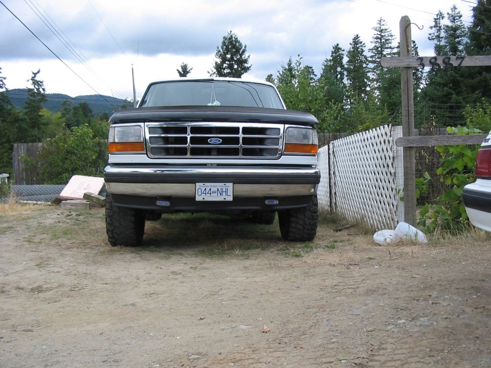 Front view of a black Ford F-Series truck with a chrome grille and a license plate reading 044-NHL