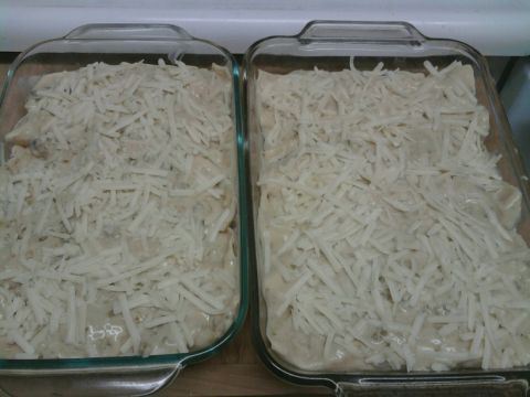 1989 Ford Bronco - Two glass baking dishes, each filled with food and covered in shredded cheese, sit side-by-side on a wooden surface.