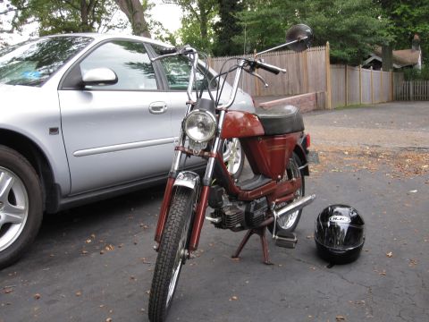 1981 Garelli Rally Sport - A red moped is parked next to a silver sedan in a driveway.