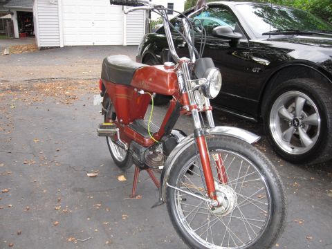 1981 Garelli Rally Sport - A red moped is parked on a driveway next to a black car, with a garage visible behind them.