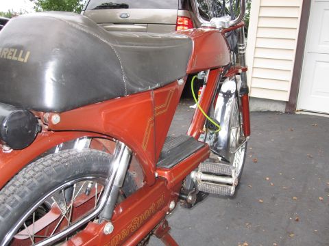 1981 Garelli Rally Sport - A red moped with a black seat and chrome accents is parked outdoors next to a building.