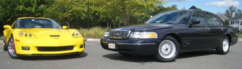 1999 Ford Crown Victoria - A black 1999 Ford Crown Victoria is seen parked next to a yellow Chevrolet Corvette.