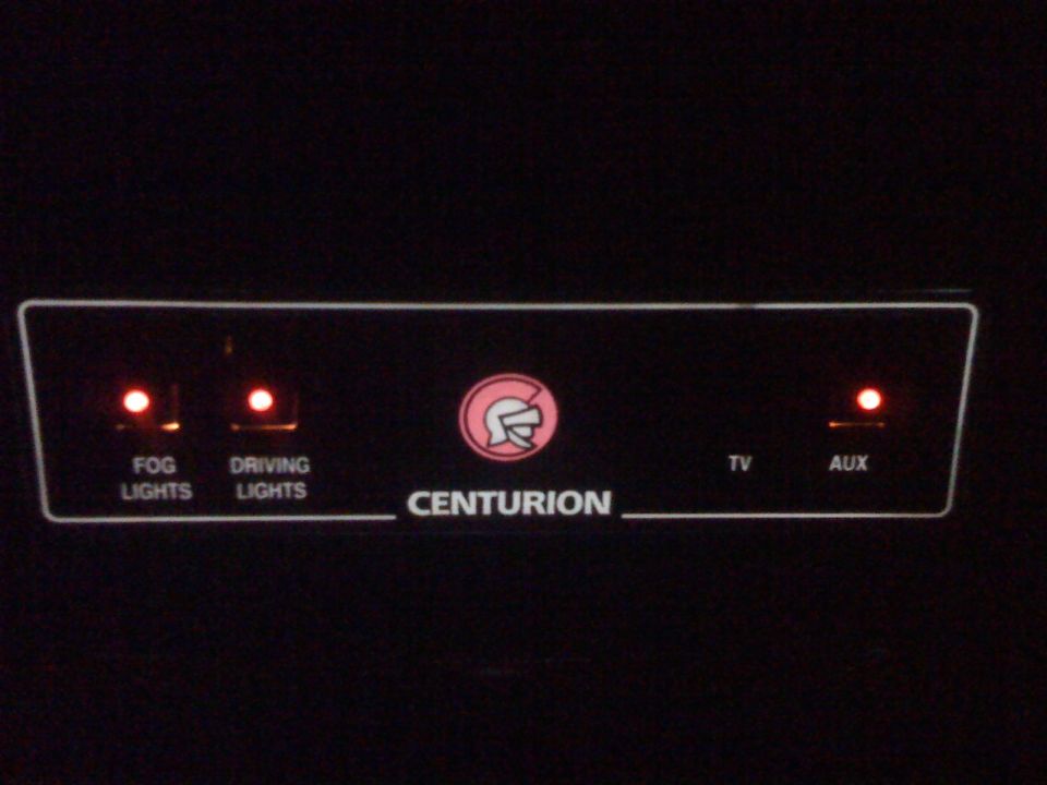 Control panel with buttons for fog lights, driving lights, TV, and AUX. Also has a Centurion logo