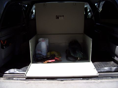1994 Ford Bronco - Interior view of a vehicle's cargo area with an open storage box containing various items.